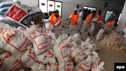 Pakistani workers of the Falah-e Insaniat Foundation in Karachi pack food to be distributed among people affected by the 7.7-magnitude earthquake in Balochistan. Foreign aid agencies have had their offers of aid rejected.