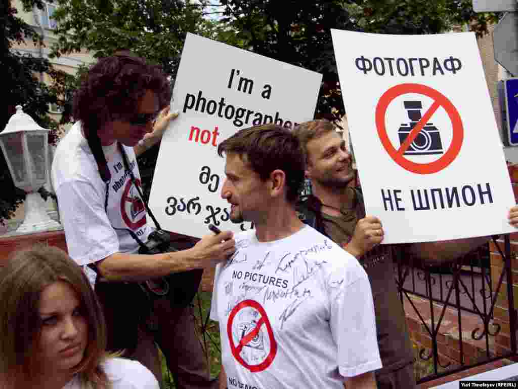 Участники акции в поддержку обвиняемых в шпионаже грузинских фоторепортеров с плакатами " I'm a photographer not a spy " " No pictures No democracy " у здания Швейцарского посольства в Москве, где представляются интересы Грузии.