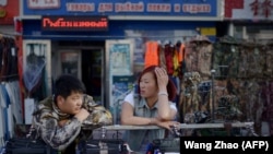 Продавцы в китайском городе Хэйхэ, расположенном на берегу Амура напротив Благовещенска