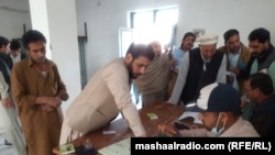 د سدې د ووټونو په مرکز کې یو کس تر خپلې رایې کارولو مخکې پر فارم ګوته لګوي. 