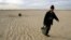 A Kazakh villager carries a bucket of water from a well in a desert that once formed the bed of the Aral Sea. (file photo)