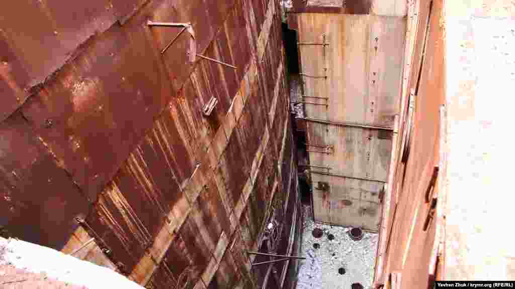 Сегодня Крымскую АЭС продолжают разбирать на стройматериалы, экскаватор гидравлическим молотом разбивает многоэтажное техническое здание, находящееся рядом с реакторным блоком АЭС