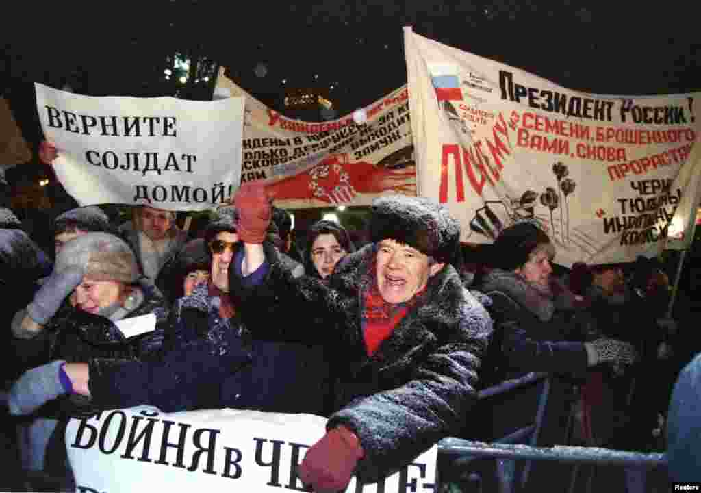 Демонстранты с плакатами выкрикивают лозунги во время митинга в Москве против боевых действий в Чечне, 10 января 1995 года. Акция протеста была организована демократической партией "Выбор России"