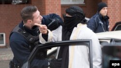 Германский полицейский разговаривает с мужчиной на улице Берлина