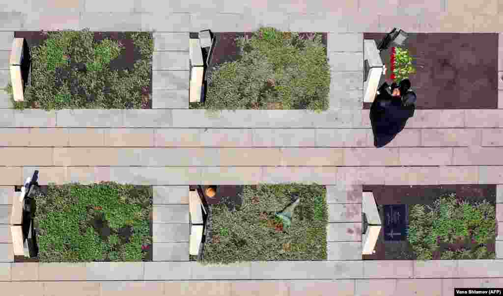 Цей знімок з пташиного польоту, зроблений 26 травня на кладовищі «Мухатгверді» в передмісті Тбілісі, показує жінку, яка сидить біля могили грузинського солдата, який загинув під час війни з Росією в серпні 2008 року (AFP/Vano Shlamov)