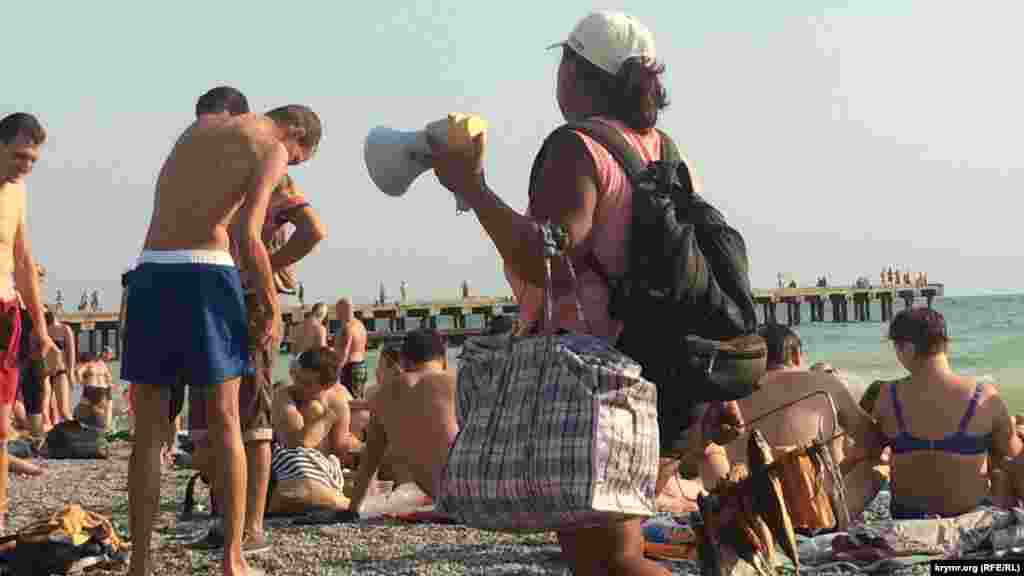 Курсирующие по пляжу торговцы с клетчатыми сумками предлагают сушеную рыбу и прочие «туристические лакомства»