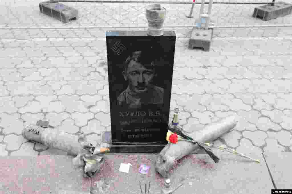 Активісти руху «Автомайдан» встановили біля будівлі посольства Росії в Києві «меморіальний знак» із портретом президента Росії Володимира Путіна в образі Адольфа Гітлера. На надгробку також зображена свастика і написи: «Ху*ло В.В. (7.10.1952 - 12.03.2015)», «Вова, не підведи» і «ПТН - ПНХ». Київ, 15 березня 2015 року