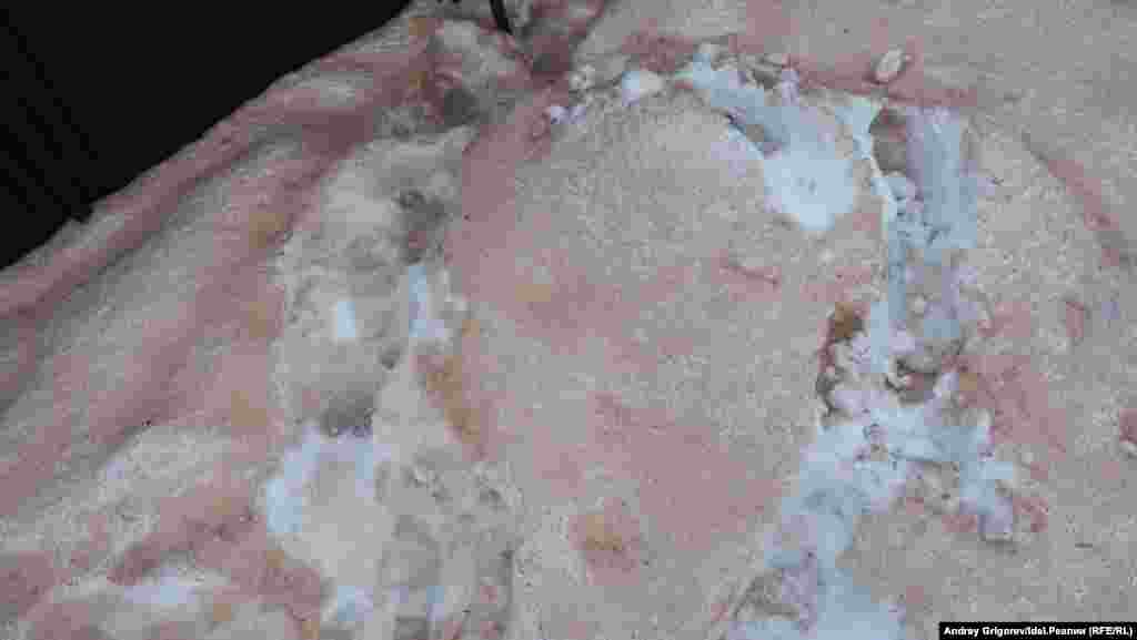 Снег вокруг огороженной площадки красный от кирпичного крошева. 