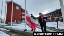 Журналіст Радіо Свобода Ростислав Хотин з прапором Гренландії під час спуску прапорів біля будівлі уряду та парламенту. Підйом прапорів щодня о 8:00, а спуск о 17:00