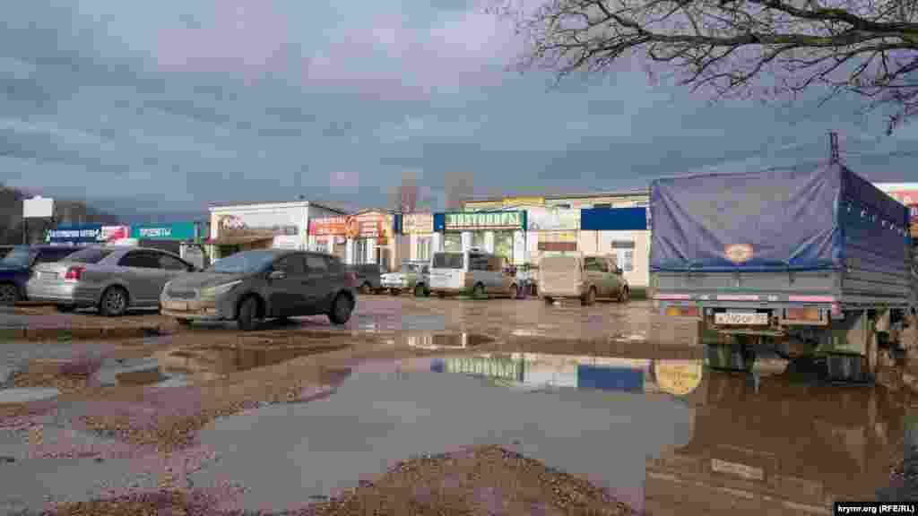 Зимнее солнце пробилось сквозь плотные облака, осветив лужи заднего двора станции и фасад торговых точек рынка «Западный»