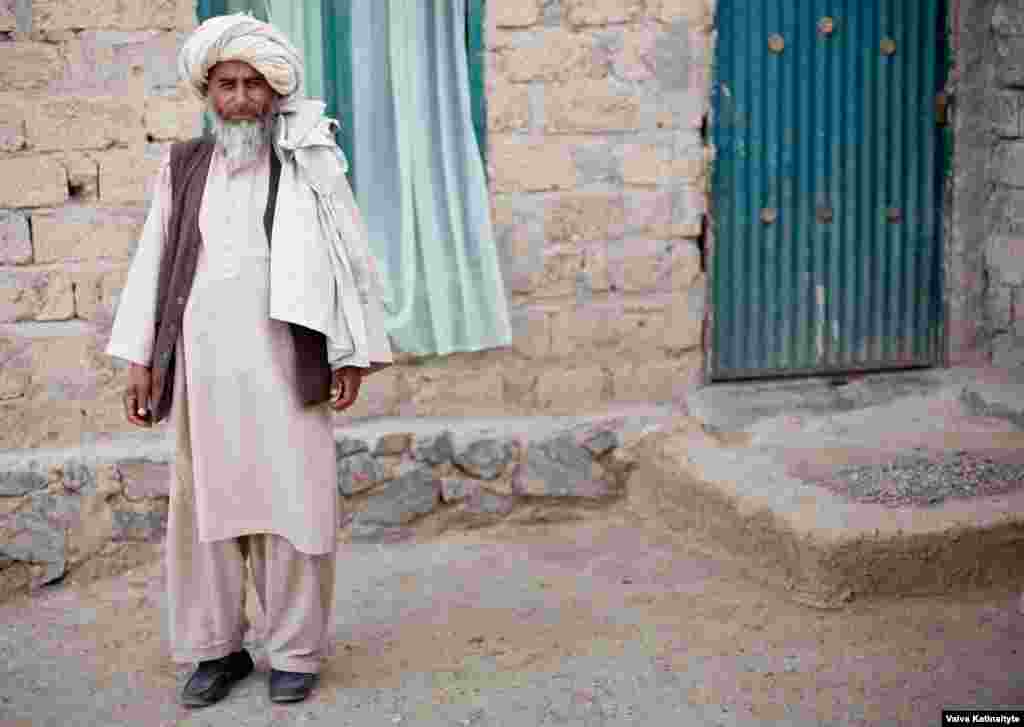 Haji Khanzada, a local elder, provides food and water for the returnees. 
