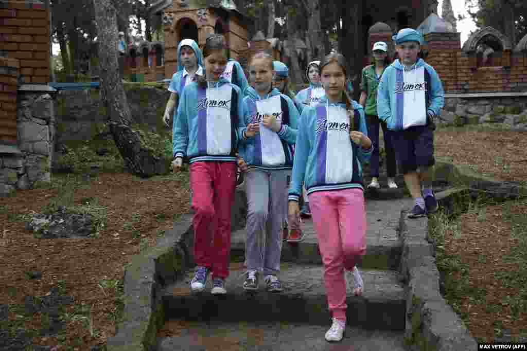 Окупований Крим. Діти в «Артеку» у травні 2015 року.Після окупації українського Криму в 2014 році Росія вклала мільйони доларів у реконструкцію приморського табору.В інтерв'ю Радіо Свобода професор Матіас Нейман заявив, що підконтрольний Росії «Артек» слугував «одночасно і демонстрацією російського відродження, і мостом до радянського минулого» з метою «формування молодих умів, просування санкціонованого державою образу історії та культивування лояльності до російської держави»