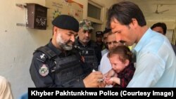 Police in Khyber Pakhtunkhwa Province's Bajaur district take part in vaccinating children again polio in September.