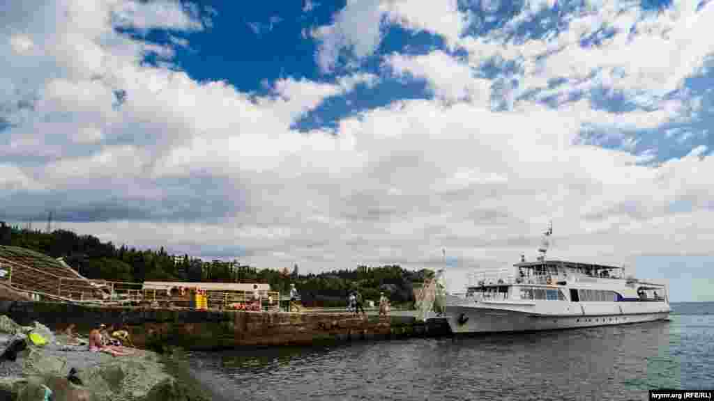 Прогулочный теплоход «А. Довженко» пришвартовался к пирсу в пляжной зоне Партенита. Прогулочный теплоход «А. Довженко» 1975 года постройки сейчас приписан к порту аннексированного Севастополя. Первым же портом приписки был Киев. Тип судна – теплоход, пассажирский катер. Его экипаж – три человека, дальность плавания – 840 миль, район плавания – морской прибрежный при волнении моря до 4 баллов. Пассажировместимость – 200 человек