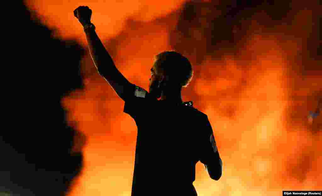 Протестувальник спостерігає, як горить ресторан швидкого харчування Wendy’s в Атланті під час мітингу проти расової нерівності через вбивство там поліцейським афроамериканця на ім’я Рейшард Брукс