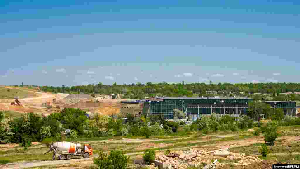 Дворец водных видов спорта на противоположной стороне объездной дороги на Ялту, в пределах «Крымской розы». Изначально, генподрядчик из Санкт-Петербурга должен был сдать объект в ноябре 2019 году, потом эту дату перенесли на следующий год. В связи с техническими нюансами, срок ввода в эксплуатацию перенесли на 31 декабря 2021 года. Недавно крымские чиновники заявили, что дворец сдадут раньше, к 1 сентября. За дворцом справа, через автодорогу на дачный массив Живописное, начинается территория нового «Абдала» – центрального городского кладбища