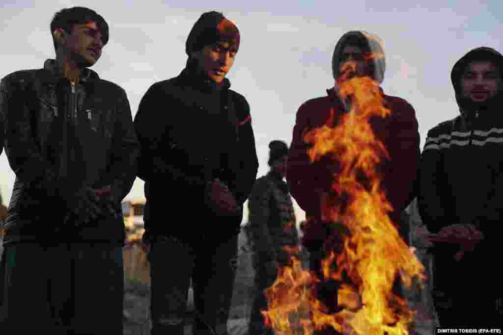 Мигранты греются у костра рядом с шоссе, ведущим к таможенной станции Ипсала на турецко-греческой границе.  