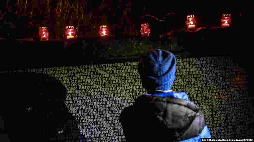 Хлопчик стоїть біля назв сіл і містечок, які постраждали від Голодомору. Під час голоду 1932–1933 років в Україні вимерли десятки сіл, сотні на десятиріччя обезлюднились