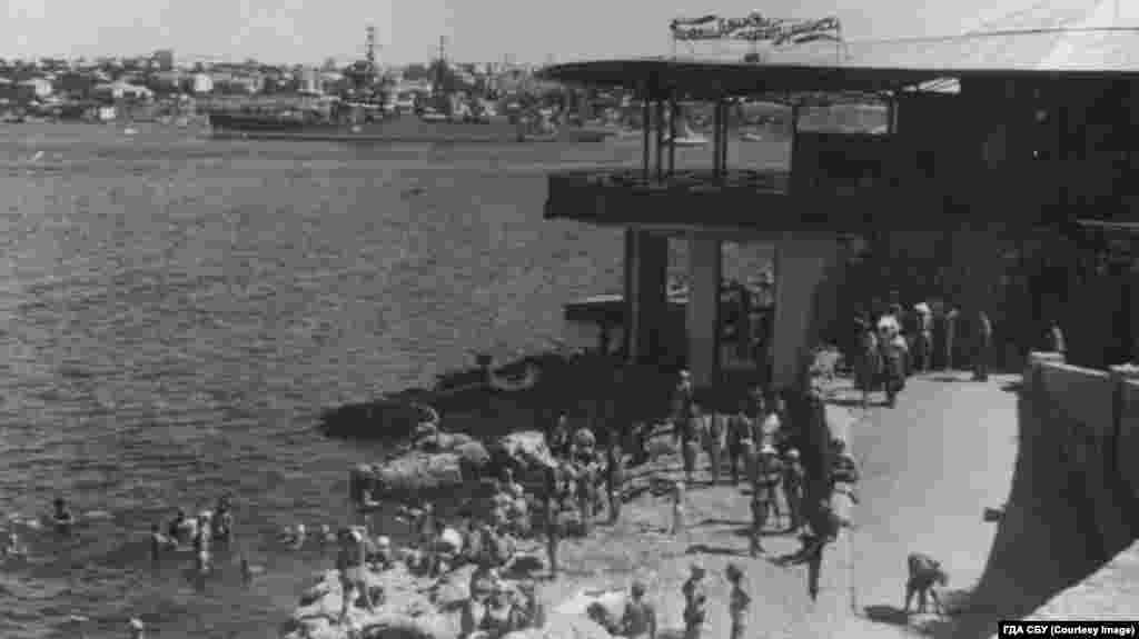 Вид с набережной на ресторан «Волна» и военный крейсер в акватории Черного моря