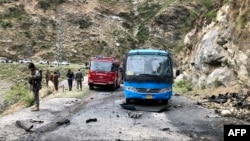 Security personnel inspect the site of a suicide attack Pakistan's Khyber Pakhtunkhwa Province that killed at least six people, including five Chinese workers.