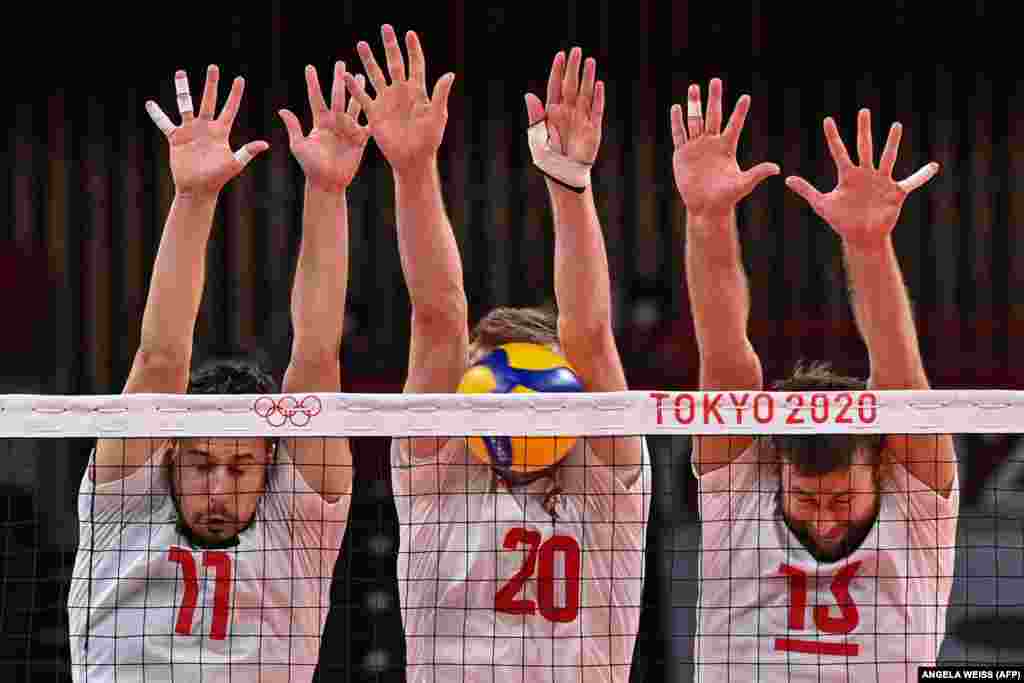 (Зліва направо) Поляки Фабіан Джизга, Матеуш Бенієк та Міхал Кубяк намагаються заблокувати м'яч у попередньому волейбольному турнірі для чоловіків із командою Венесуели. Токіо, 28 липня 2021 року
