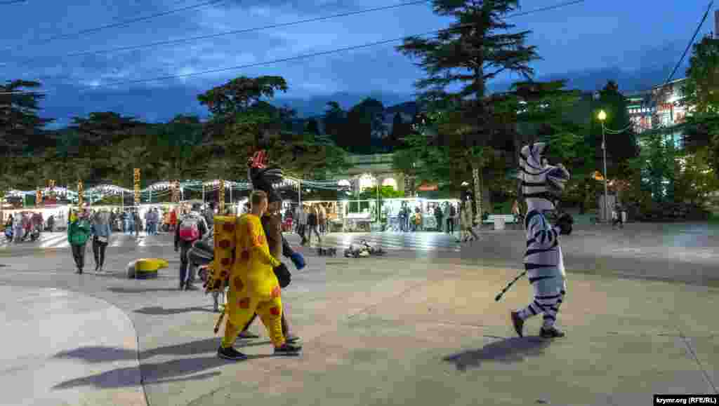 Аниматоры спешат по своим делам на набережной 