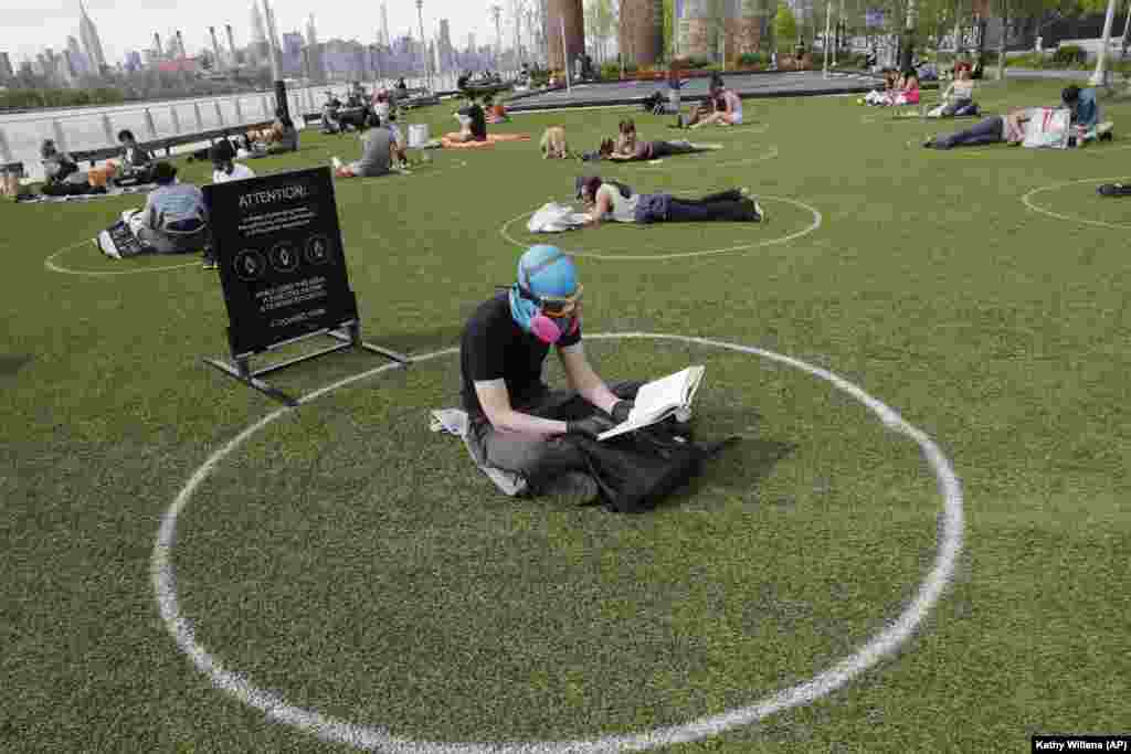 Як відпочити в одному з парків у Нью-Йорку у США під час пандемії? Дехто обирає собі такий спосіб: у гумовій шапочці для підводного плавання, захисних окулярах, респіраторі з повітряним фільтром і гумових рукавичках! І, звісно, в межах визначеного на траві кола. Вони позначають місця з безпечною дистанцією, щоб убезпечитися від зараження – їх намалювали після того, як тиждень тому в незвично теплі дні парк виявився просто переповненим
