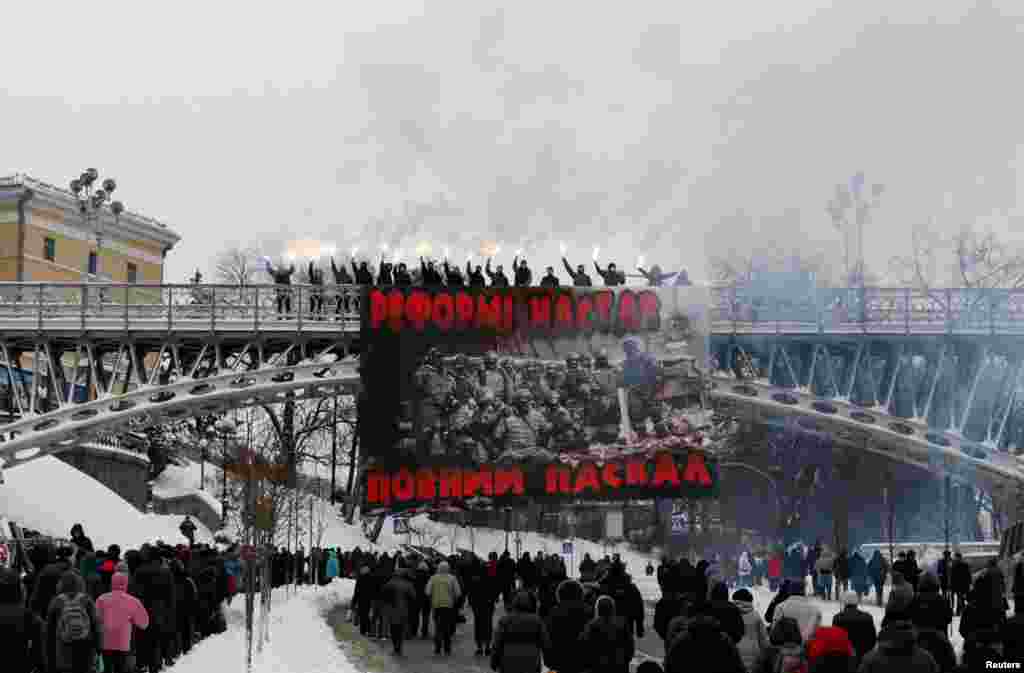 Активисты держат горящие факелы во время акции протеста против расширения полномочий полиции и власти в центре Киева, 14 ноября (Reuters/Valentyn Ogirenko)