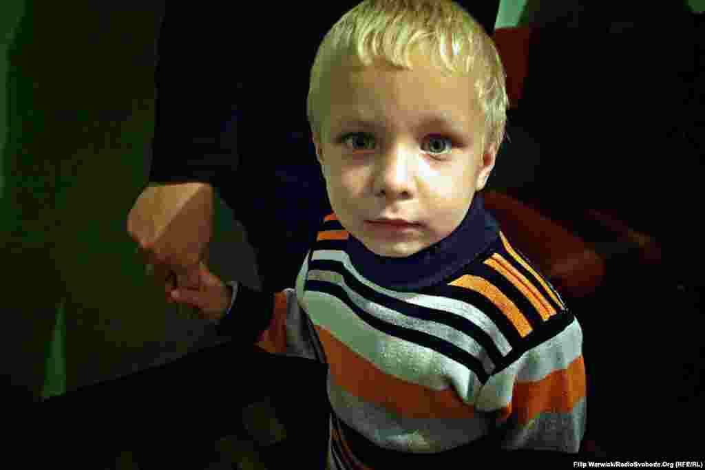 Дитина з сім’ї переселенців, які зараз мешкають у студентському гуртожитку. За українським законодавством, діти не можуть відвідувати школу без відповідного документа про попередню освіту. Під час евакуації нерідко траплялися випадки, коли батьки лишали документи своїх дітей на окупованих територіях