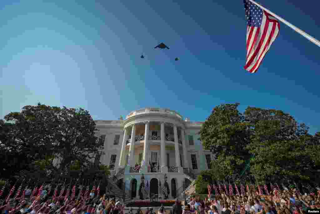 Президент США Дональд Трамп и первая леди Мелания Трамп смотрят, как самолет B-2 Spirit и два самолета F-35 принимают участие в пролете, отмечая День независимости, Вашингтон, США, 4 июля 2025 года. REUTERS/Ken Cedeno