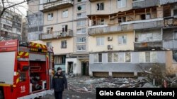 Спасатели на месте попадания российского дрона в Киеве, 23 марта 2025 года