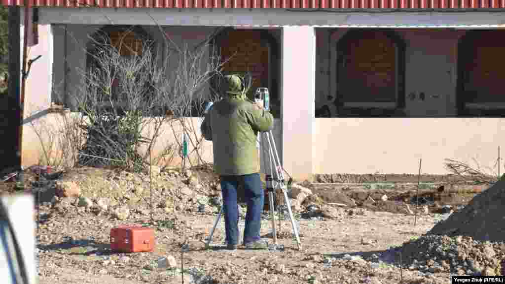 Мужчина делает замеры с помощью теодолита 