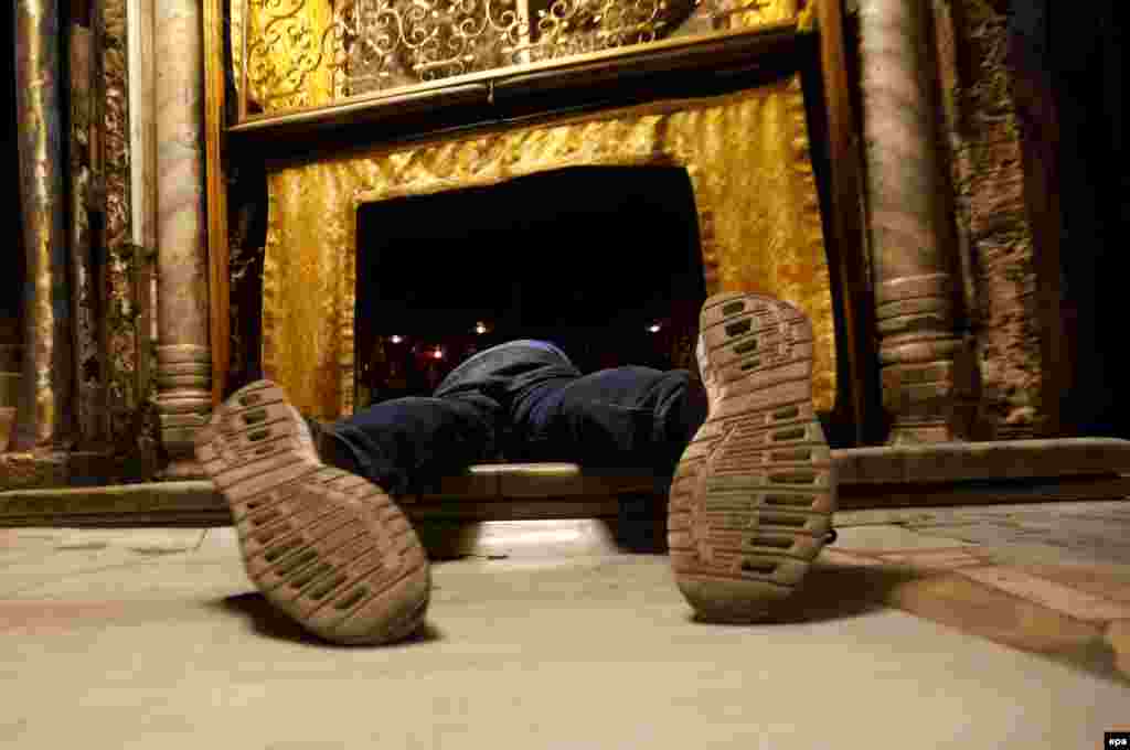 Православный верующий молится в Вифлееме, в том месте, где, как считают, родился Иисус Христос. 22 декабря 2015 года. 