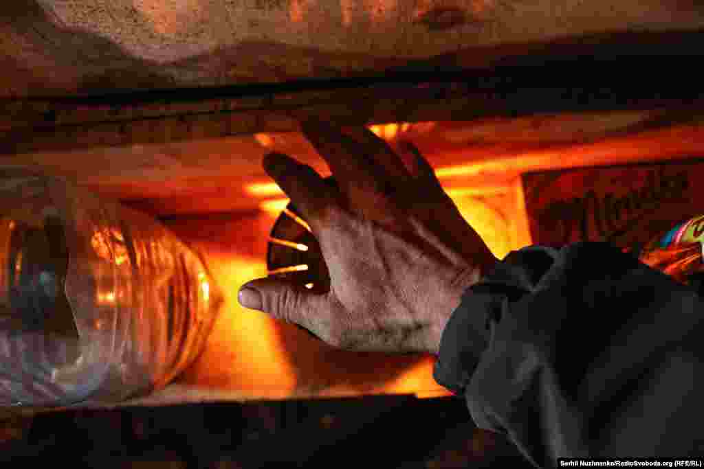 Військовий гріє руки біля окопної свічки. Серебрянський ліс, лютий 2024-го 