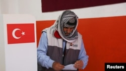 Чоловік тримає бюлетень для голосування на виборчій дільниці під час місцевих виборів у Діярбакирі, Туреччина, 31 березня 2024 року