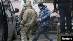 Одного з українських моряків виводять з будівлі суду в Сімферополі, 27 листопада 2018 року