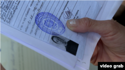 Крымчанка Ирина Буняк держит в руках документ об отбывании тюремного наказания в России