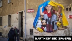 Мурал, що зображує дитину, яка ховається від війни під прапором України, створений вуличним художником ChemiS. Прага, Чехія, 21 березня 2022 року