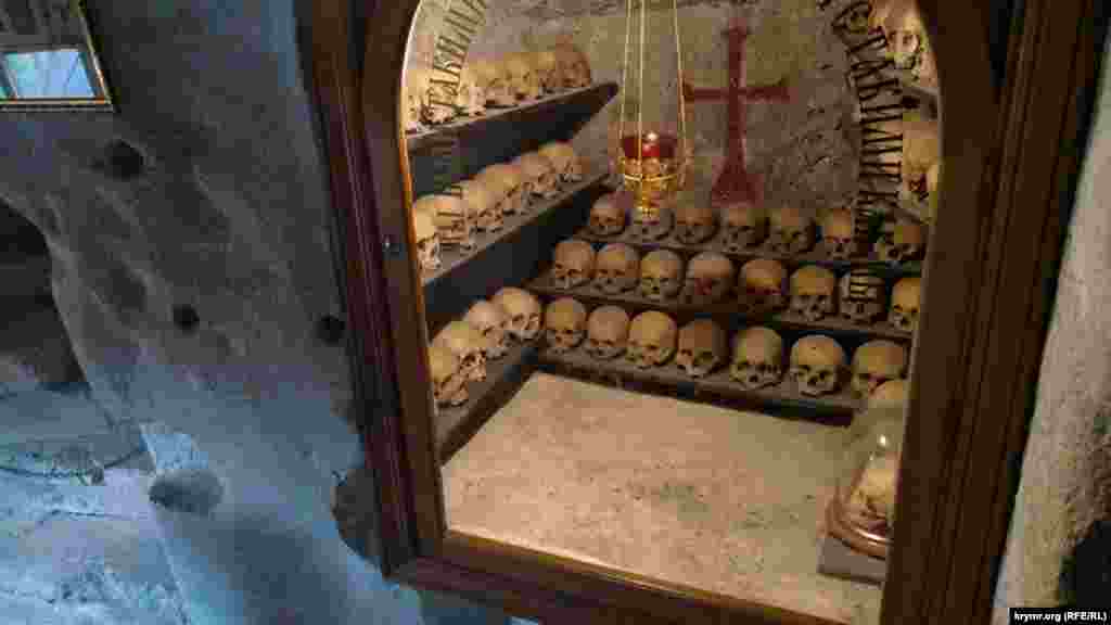 Костница в стене храма. На стекле склепа написано: «Мы были такими же, как вы. Вы будете такими же, как мы»