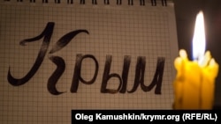 Надпись «Крым» и горящая свеча. Иллюстративное фото