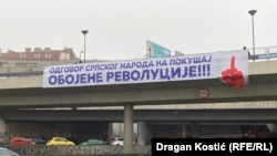 Transparent sa krvavom šakom koja pokazuje srednji prst na Autokomandi u Beogradu, 21. januar 2025.