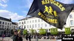 Žena maše zastavom u znak protesta ispred Evropskog parlamenta uoči glasanja o reformi politike azila i migracija, Brisel, 10. april 2024.