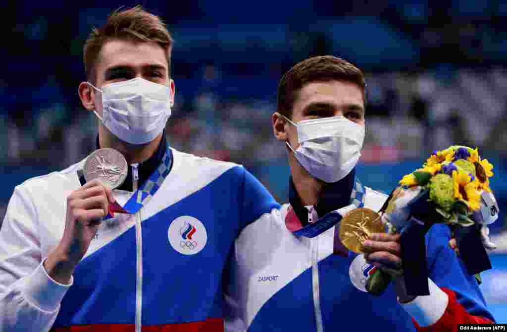 Золотий призер із Росії Євген Рилов (праворуч) і срібний призер із Росії Климент Колесніков позують свої медалі після фінального запливу на 100 метрів на спині серед чоловіків. Токіо, 27 липня 2021 року  