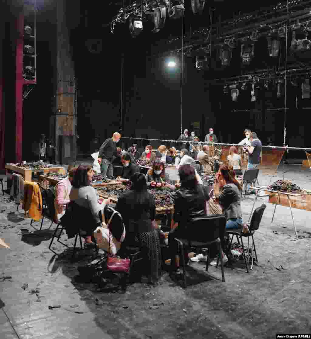 Жінки сортують клаптики тканини на головній сцені театру. Окрім маскувальної сітки, яка використовується для приховування військових позицій та бронетехніки, за словами Агаджаняна, волонтери також виготовляють одяг та інші предмети, необхідні на передовій  