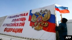 Russia -- A Russian emergency situations ministry driver places a Russian flag on his truck as a humanitarian convoy bound for the regions of Luhansk and Donetsk in Ukraine prepares to depart from the ministry base near Rostov-na-Donu, October 30, 2014