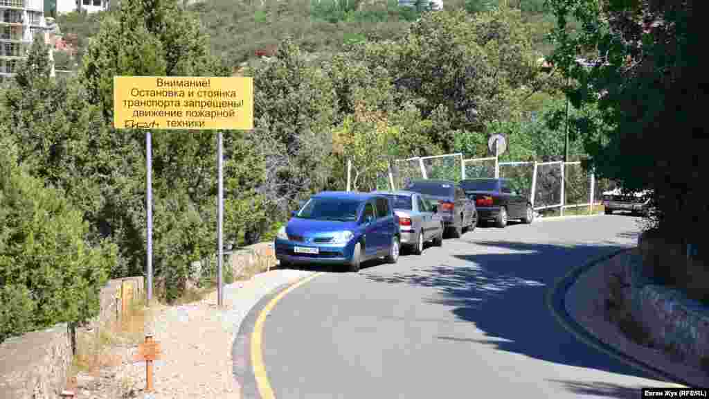 Несмотря на предупреждающие таблички, узкая дорога заставлена автомобилями – парковок в Ласпи нет