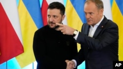 Прем’єр-міністр Польщі Дональд Туск (праворуч) тисне руку президента України Володимира Зеленського на спільній пресконференції у Варшаві, Польща, 15 січня 2025 року