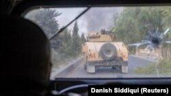 A member of the Afghan special forces fires at Taliban militants after coming under heavy fire during the rescue mission of a police officer besieged at a check post in Kandahar Province on July 13.