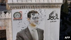 Portret Bašara el-Asada izrešetan mecima u gradu Hama, 6. decembar 2024.