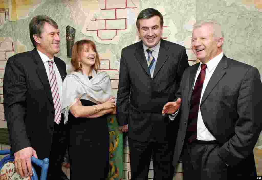 Лідер Соціалістичної партії України Олександр Мороз (праворуч) жартує з лідерами української опозиції Віктором Ющенком і Юлією Тимошенко та з Міхеїлом Саакашвілі, лідером Революції троянд у Грузії, яка змусила піти у відставку президента Едуарда Шеварднадзе. Міхеїл Саакашвілі заявив, що не має рецепту «революції» в Україні, і закликав народ вирішити свою долю самостійно наступного року. Київ, 13 грудня 2003 року